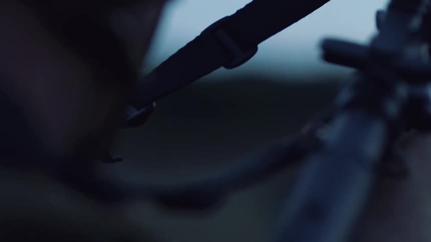 A soldier aims and shoots his gun