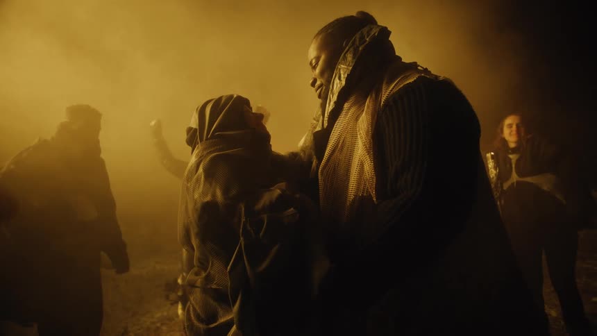 A man and a woman talking and hugging while surrounded by people dancing