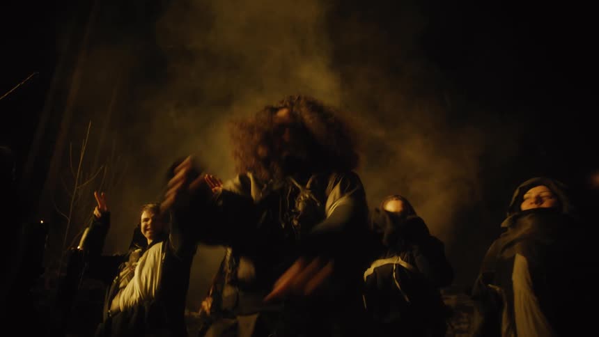 Group of people dancing in the forest at night
