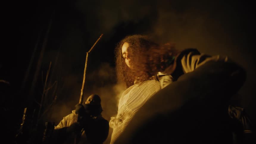People in costumes dancing outdoors at night