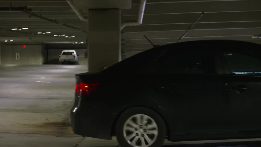 Car drives down the ramp of a parking garage