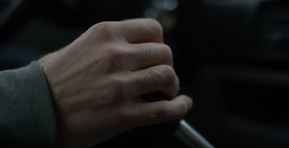 Hand of a man shifting gears inside a car