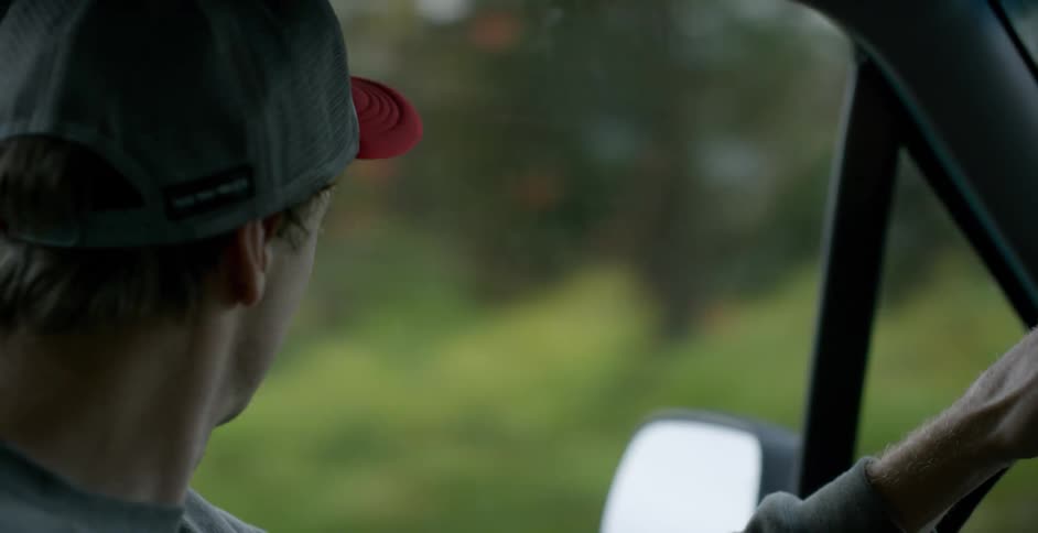 Interior view of young man driving car through countryside