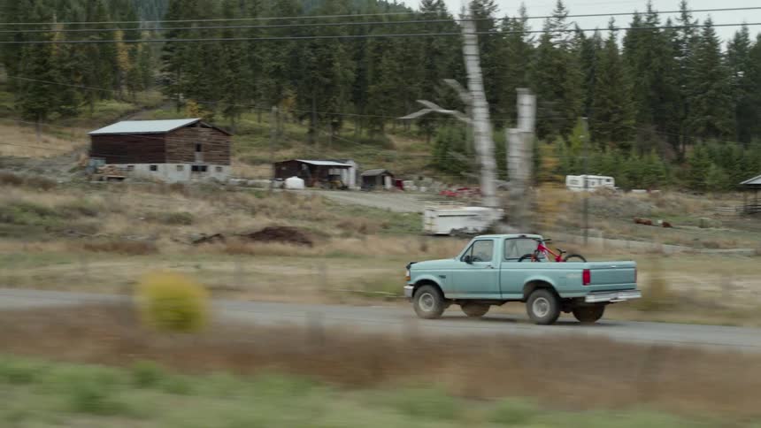 A truck drives through a rural area