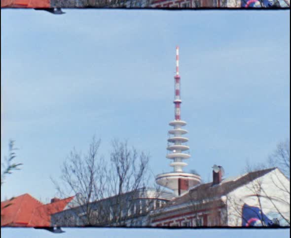 A tall spire shaped structure rises above neighborhood housing