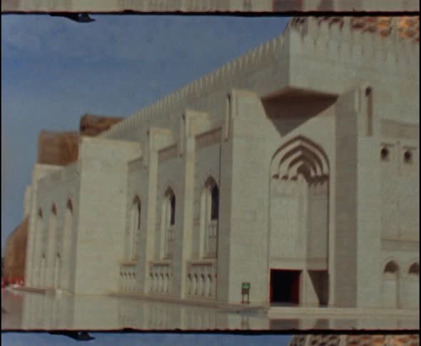 Stone plaza in front of a gold domed building on a bright sunny day