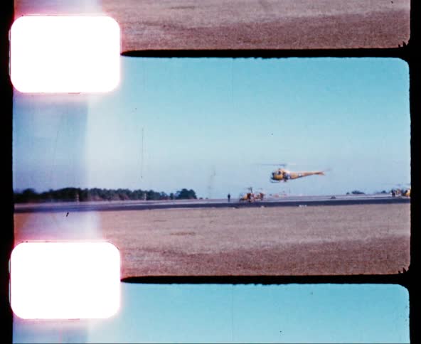 A military helicopter hovers over an airfield