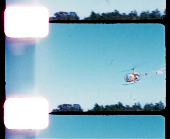 Vintage footage of helicopter taking off from tarmac in countryside