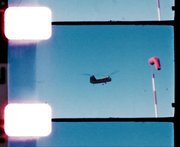 A tandem rotor helicopter descending from the sky on a sunny day