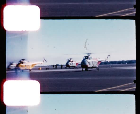 Military helicopter taxis at the airport as other helicopters sit nearby