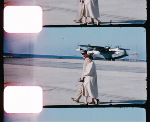 A military officer and his wife walking along a military runway