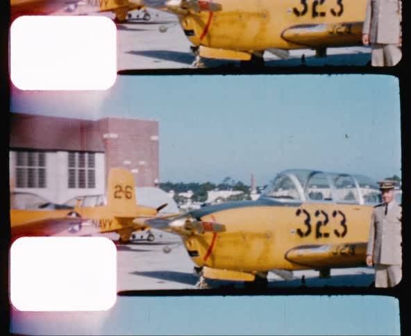 Male pilot stands next to a yellow navy airplane