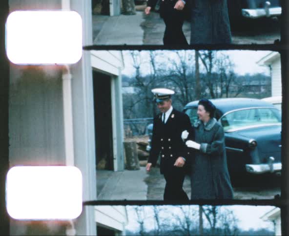 A mother and her military officer son walk from a car to the front door of a house