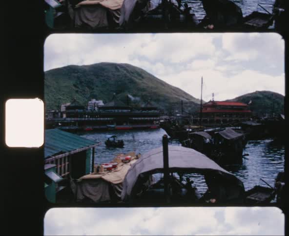 Ships and wooden boats crowding the waters of a bay