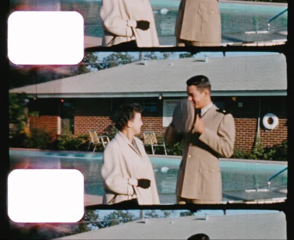 A military man and a woman stand next to a home pool
