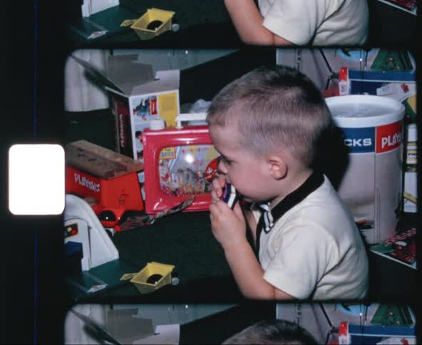 Little boy plays blue toy harmonica
