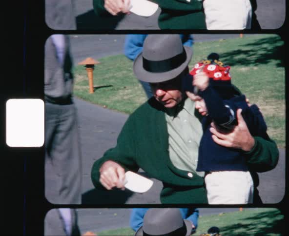 An older man shows a child how to throw a fish