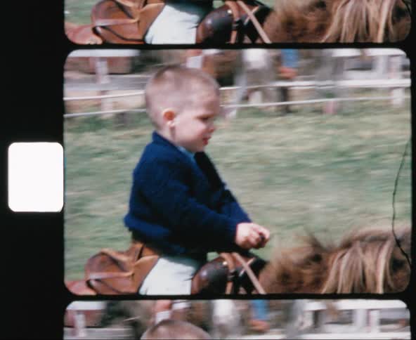 A white male child rides a pony on a track