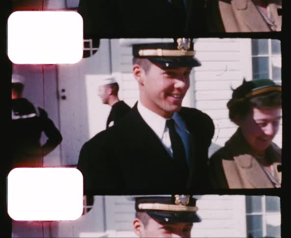 A mother and her naval officer son walk away from a building