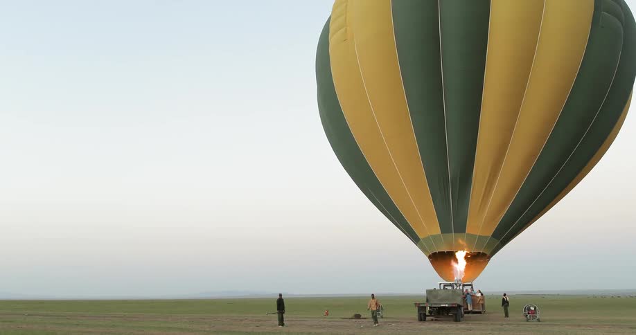 People stand around as a hot air balloon fills