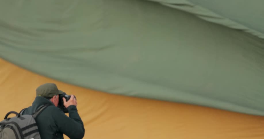 A photographer takes photos while standing close to a hot air balloon being inflated