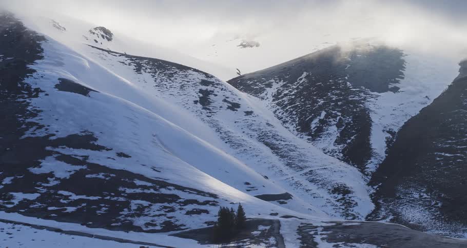 Aerial push towards a surreal snowy valley at sunset