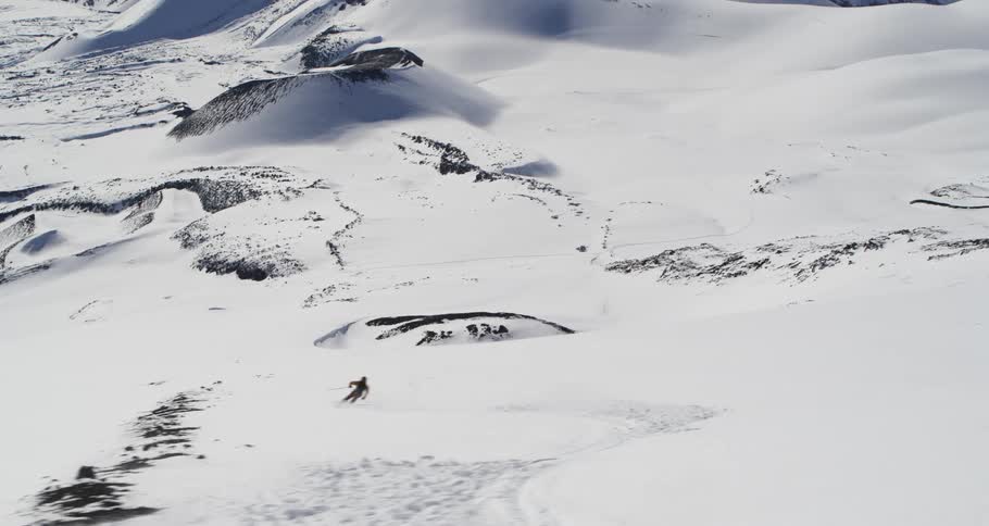 Aerial of a skier making turns on a big slope