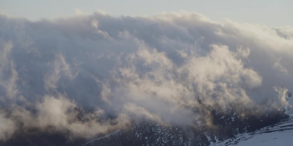Sunset clouds fill the sky over a snow covered forest