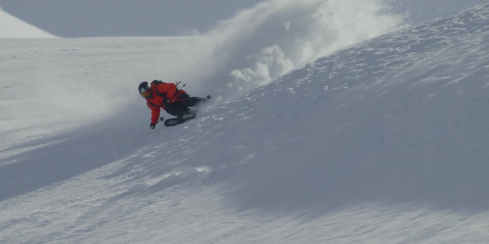 A skier sprays snow on a big turn