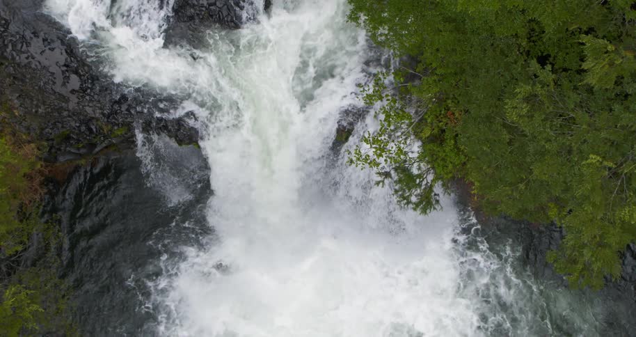 Aerial descending on a waterfall crashing in to the river below