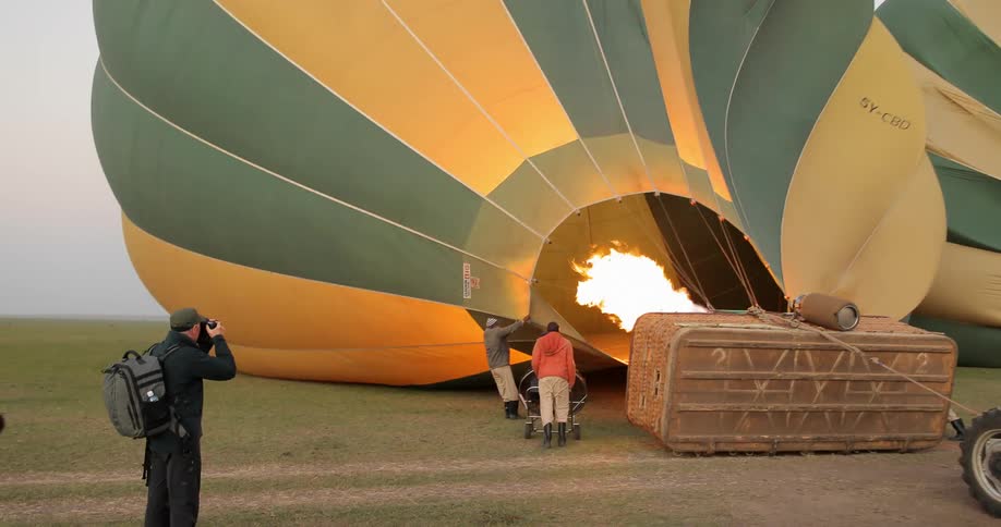 People gather around a hot air balloon laying on its side