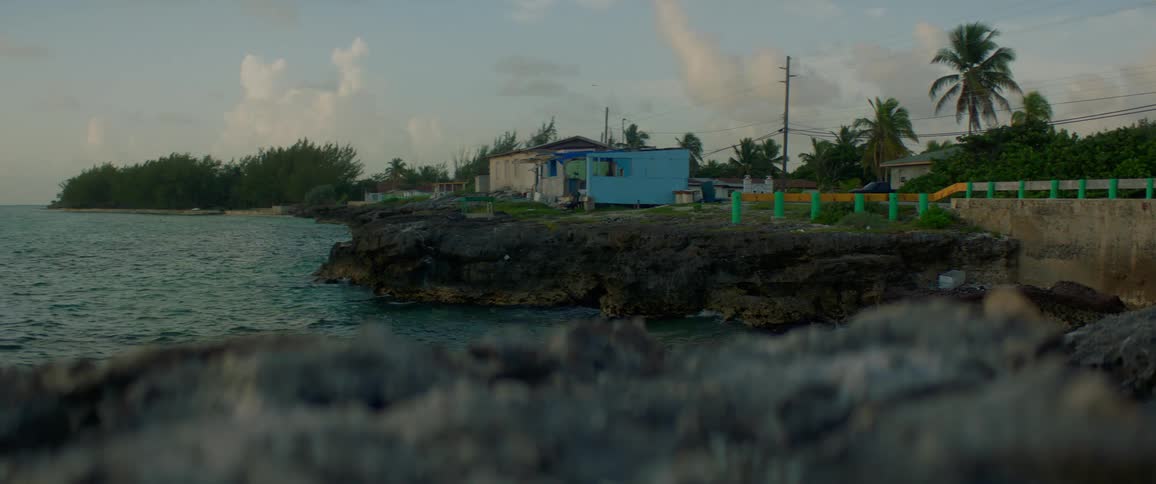 Several homes sit on a rocky coast by the ocean