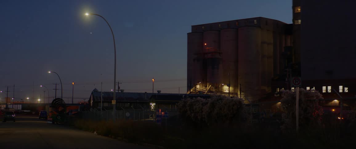 A factory sits off an urban road