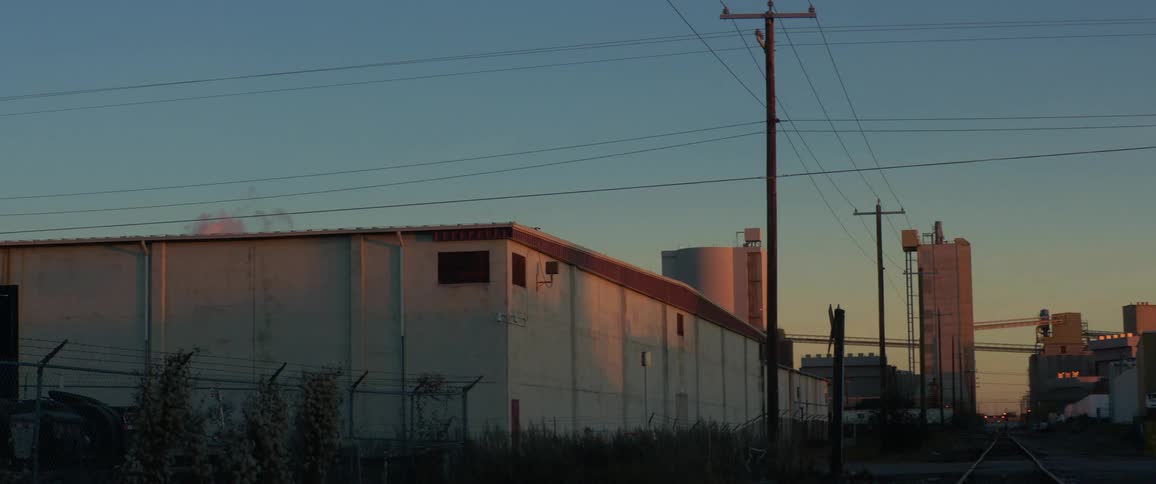 The sun sets over a neighborhood near train tracks