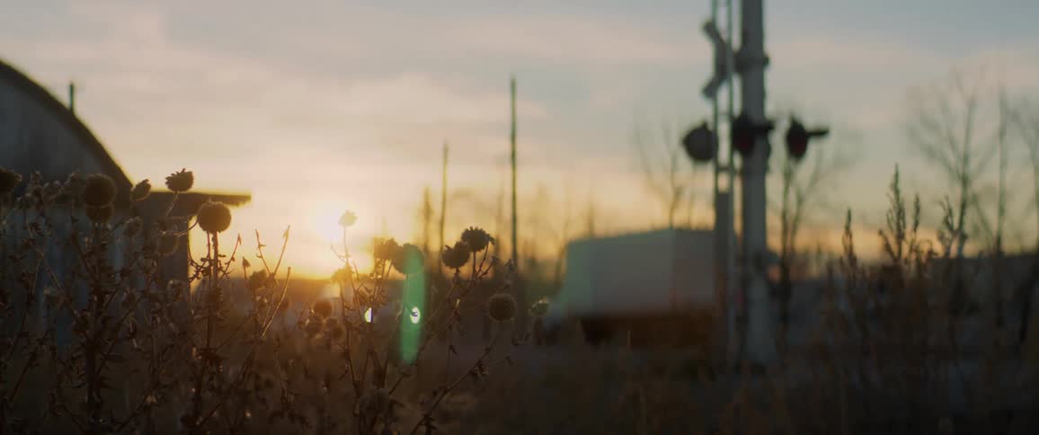 Vehicles drive on countryside highway at sunset