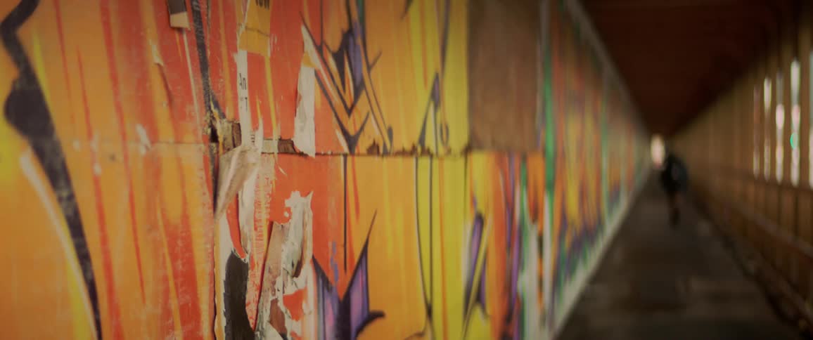 Person runs down graffiti lined hallway