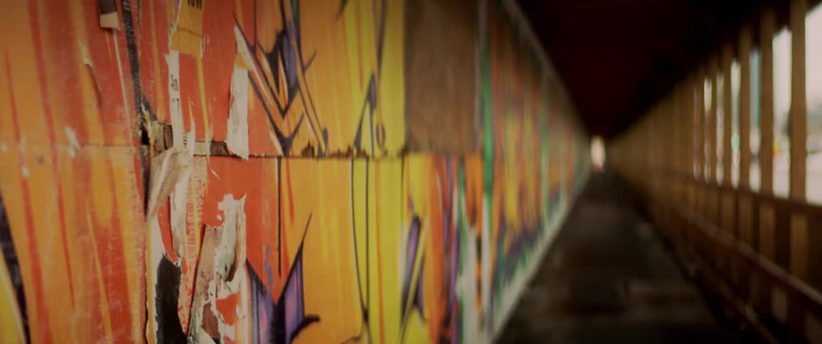 Painted murals line the wall of a walkway
