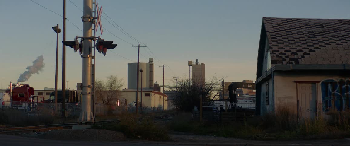 Abandoned building and railroad track in industrial area of town at dawn