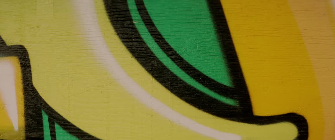 Color graphics and shapes are drawn on a yellow wall with an unfinished portion