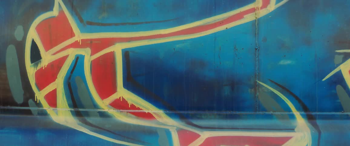A red and yellow creature is painted on a blue wall