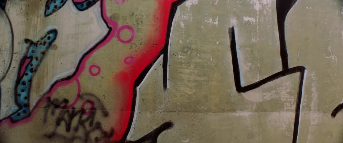 Black forms outlines of graffiti on outside wall