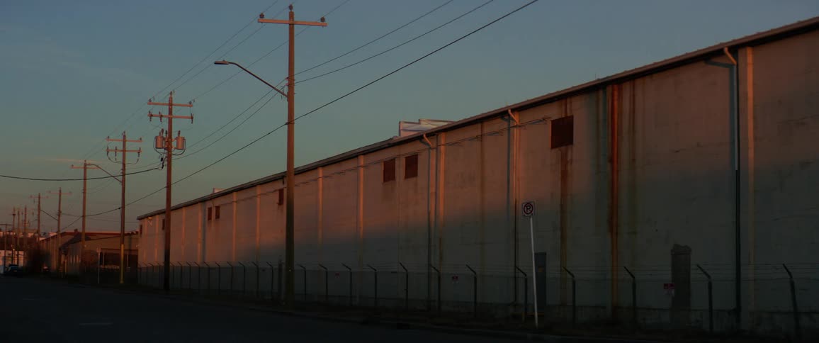 A large building sits behind a chain fence
