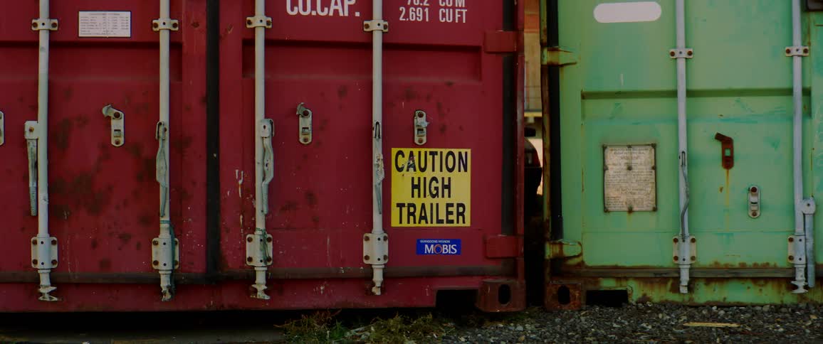 Two rusted shipping containers sit side by side