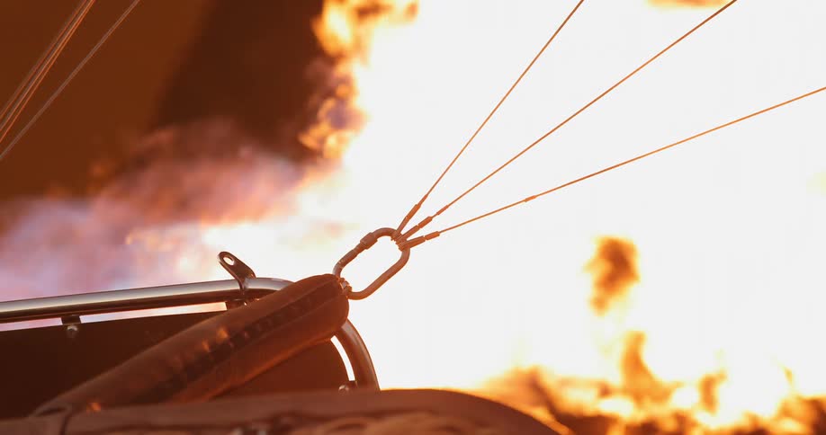 The flame of a hot air balloon burns brightly