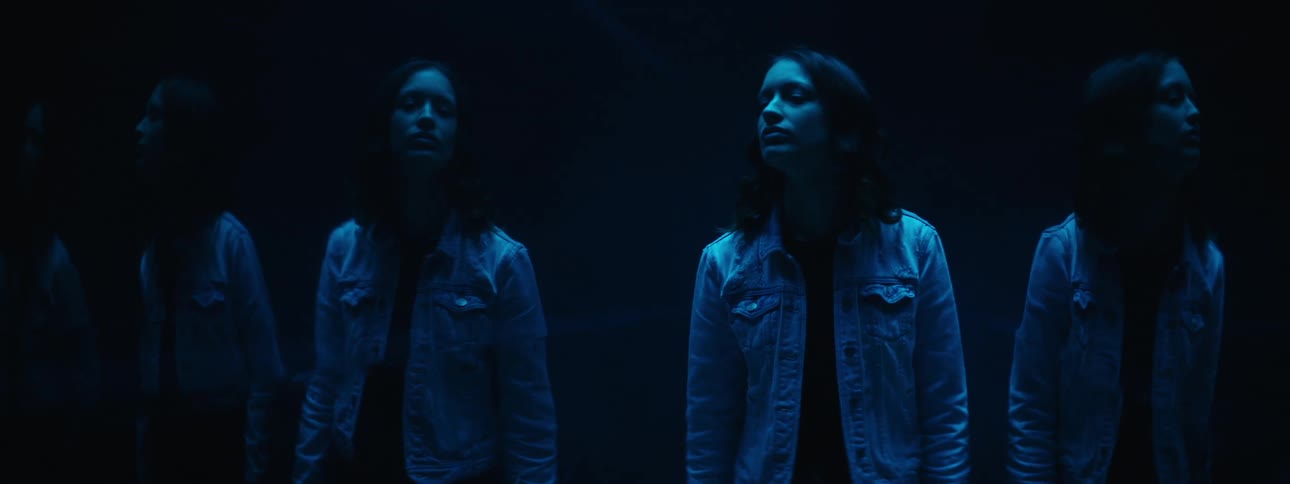 A teenager walks along and her reflection is shown several times