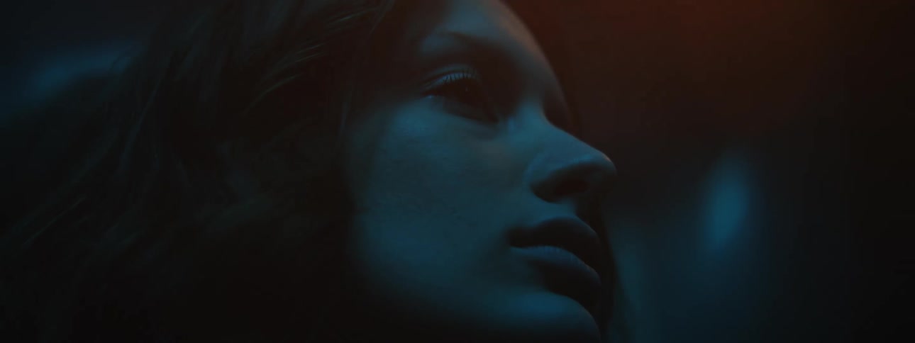 Woman looks up and around in dark shadowy room