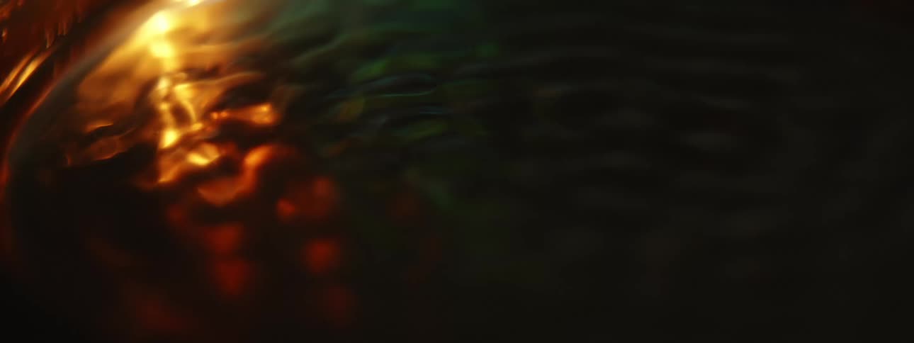 A liquid vibrating at high speed in a container in a dimly lit room