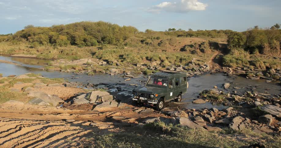 A truck drives across a river