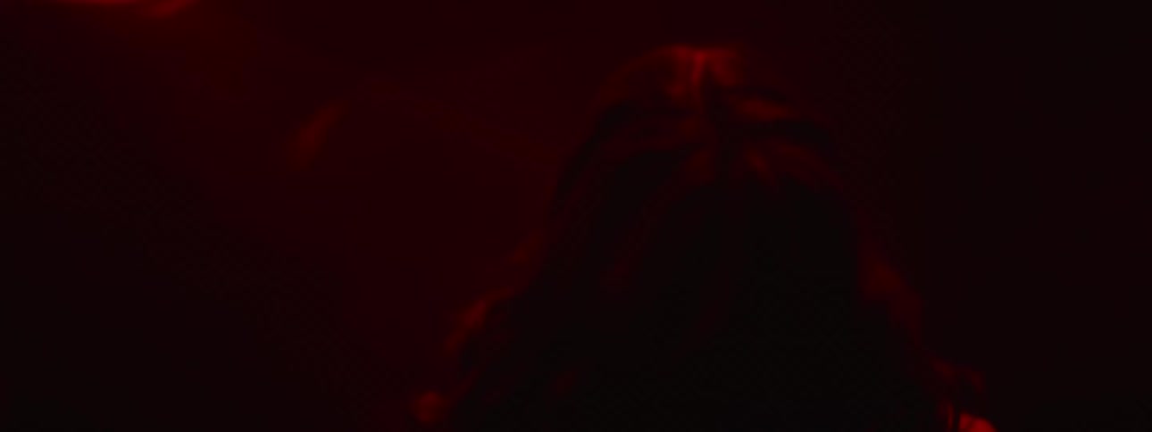 Two teenage girls stand in the dark and look around