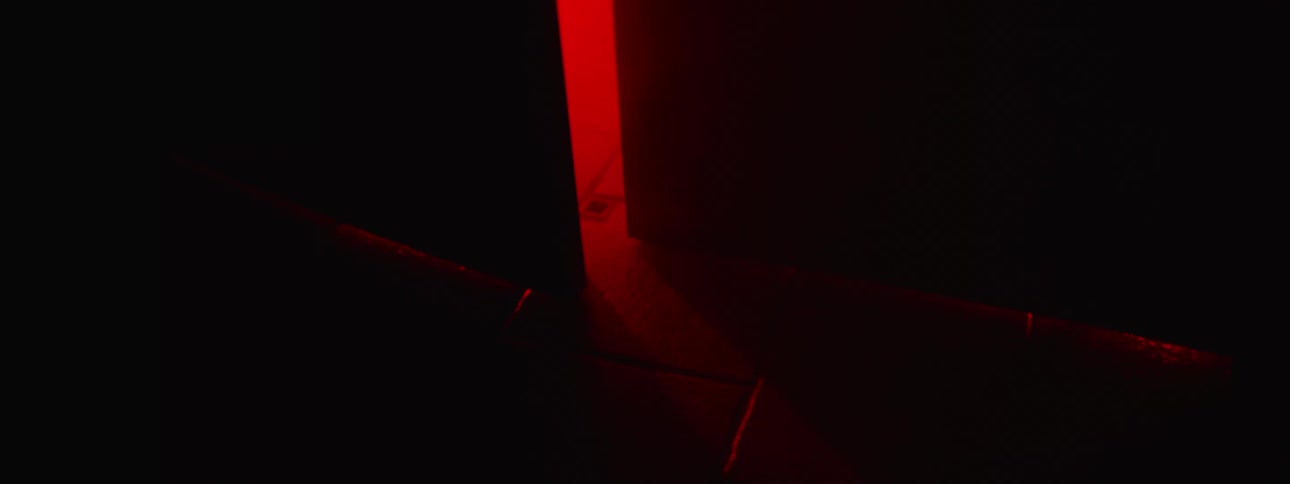 Red light shines through a partially open door